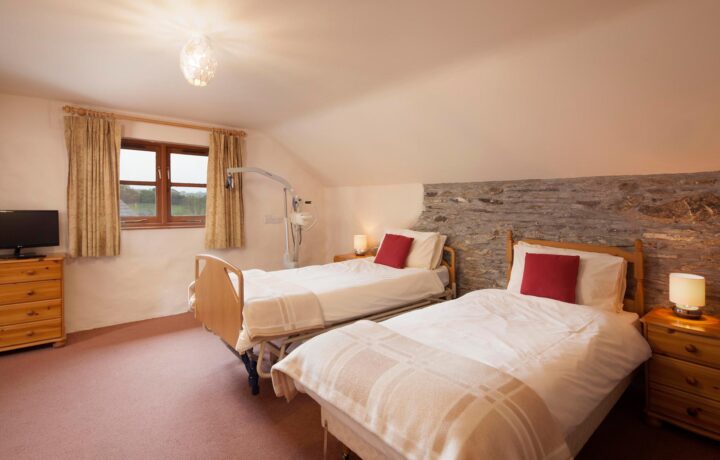 Valley View accessible bedroom with hoist, electric profiling bed, TV and ensuite wheel in wetroom.