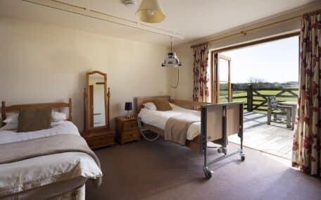 Acceddible bedroom equipped with ceiling hoist and 4 section electric profiling bed.