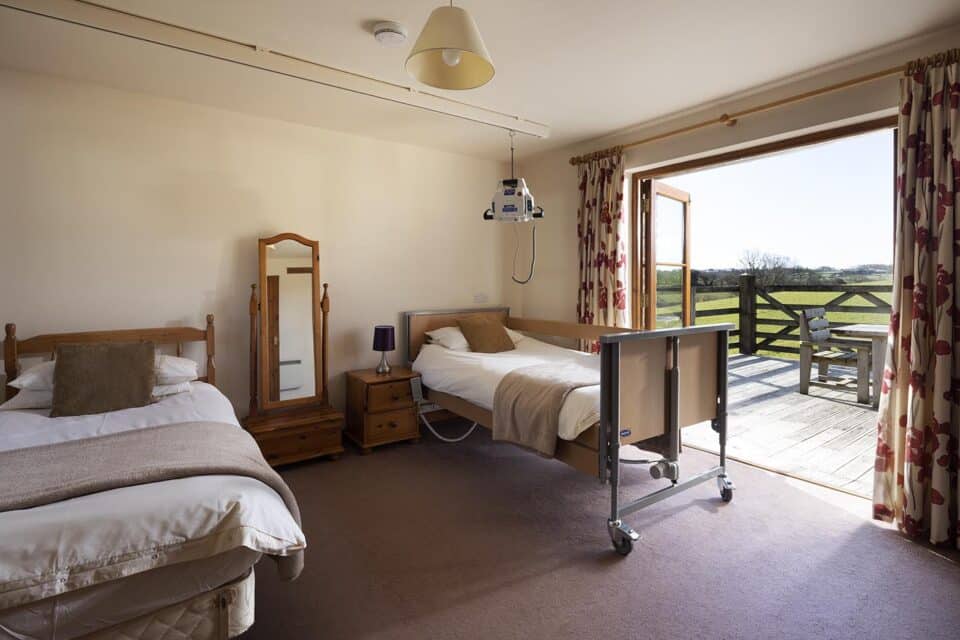 Acceddible bedroom equipped with ceiling hoist and 4 section electric profiling bed.