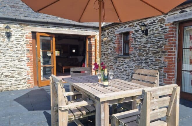 The level patio opens up from the sitting room and is equipped with outdoor furniture and a BBQ
