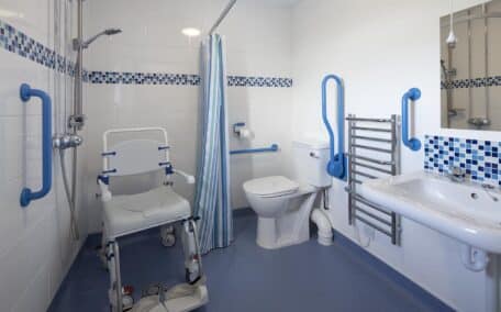 The wheel in ensuite wetroom in Buzzard Watch has several grab rails and drop down rails for safe use and has a raised toilet