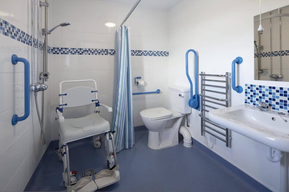 The wheel in ensuite wetroom in Buzzard Watch has several grab rails and drop down rails for safe use and has a raised toilet